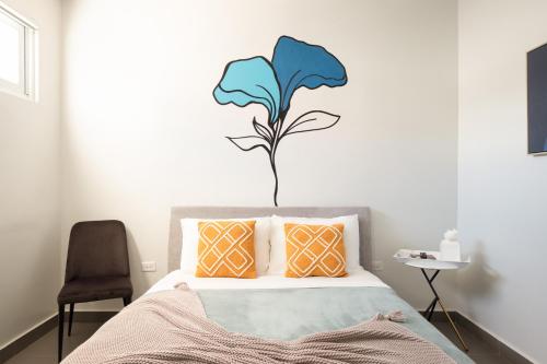 a bedroom with a bed with a blue flower on the wall at Rosalina Ocean Park in San Juan