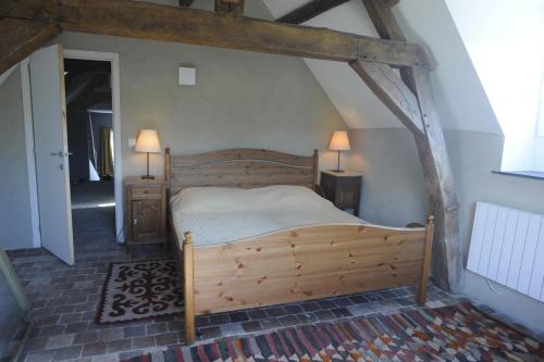 a bedroom with a wooden bed in a attic at La ferme aux oiseaux B&B in Beaumont