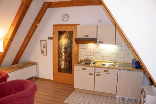 - une cuisine mansardée avec un évier et un comptoir dans l'établissement AD2-33 - Appartement Typ D, à Dorum Neufeld