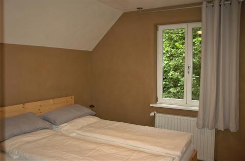 a bed in a bedroom with a window at GASTHAUS Porzelt -Ferien im Weingut - Wohnung 2 in Klingenmünster