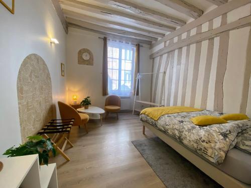une chambre avec un lit, une table et des chaises dans l'établissement Joli studio hyper centre, à Rouen
