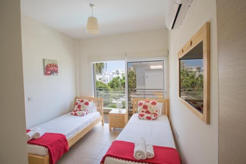 ein kleines Zimmer mit 2 Betten und einem Fenster in der Unterkunft Protaras Delfini Villa Dv4 in Protaras