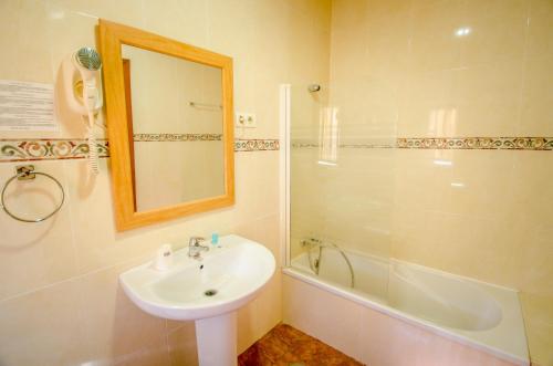 a bathroom with a sink and a shower and a mirror at Hotel Solymar in Málaga