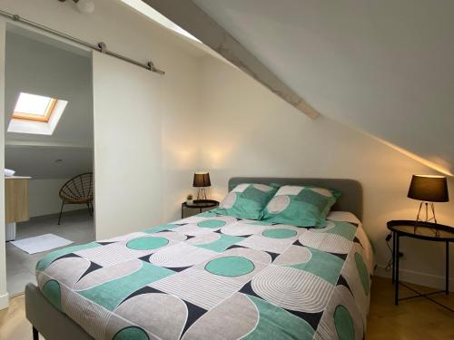 Un dormitorio con una cama grande con almohadas verdes. en Le Loge'Mans, en Le Mans