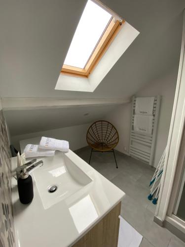 baño con lavabo blanco y ventana en Le Loge'Mans, en Le Mans