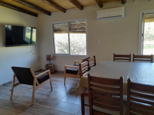a dining room with a table and chairs and a tv at Finca La Calma in San Rafael