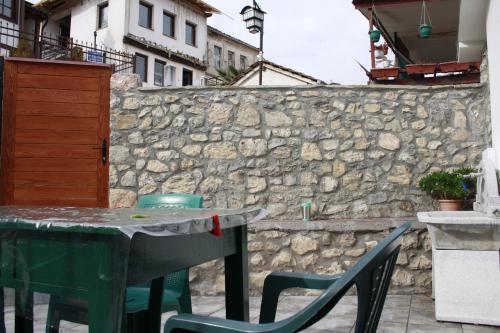 a table and chairs in front of a stone wall at Old Town Patio House in Ohrid
