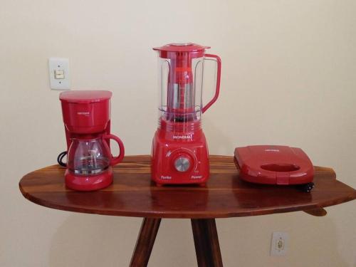 a red blender on a wooden table next to a toaster at LAGOA II SAQUAREMA RJ in Saquarema