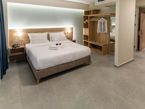 1 dormitorio con 1 cama blanca grande y baño en Armonia Apartments, en Keramotí