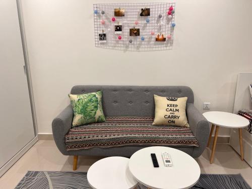 a living room with a couch and two tables at Vinhome Grand Park Homestay House in Gò Công