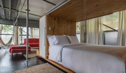 a bedroom with a large bed and a hammock at Baubrasil Village in Tiradentes