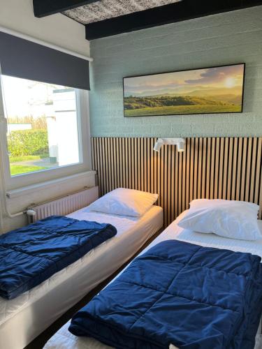 two beds sitting in a room with a window at Vakantiebungalow nr 7 in het Heuvelland in Simpelveld