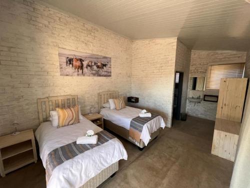 1 Schlafzimmer mit 2 Betten in einem Zimmer in der Unterkunft Kaoko Bush Lodge in Kamanjab