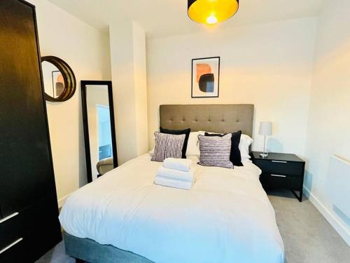 sypialnia z dużym białym łóżkiem z poduszkami w obiekcie Modern one bedroom apartment near Old Trafford Stadium w Manchesterze