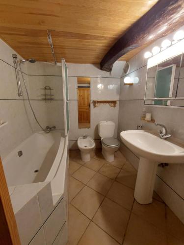 La salle de bains est pourvue d'un lavabo, d'une baignoire et de toilettes. dans l'établissement Chambres d'hôtes : Les maisons de Gaïa, à Tuchan