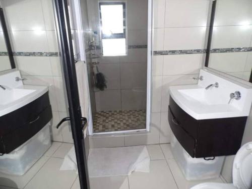 een badkamer met een douche, een wastafel en een toilet bij Reflections at 21 in East London