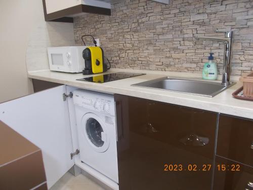 a kitchen with a sink and a washing machine at Апартамент ВАНЕСА in Velingrad
