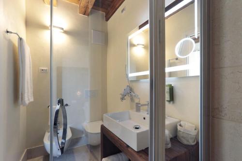 La salle de bains est pourvue d'un lavabo, de toilettes et d'un miroir. dans l'établissement Hotel Antica Abbazia, à Borso del Grappa