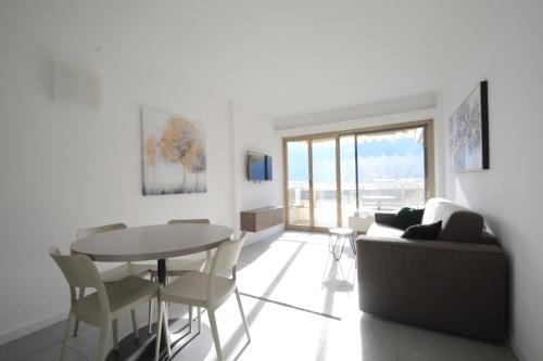 ein Wohnzimmer mit einem Tisch und einem Sofa in der Unterkunft La Costa di Alex in Minusio