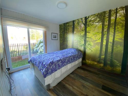 a bedroom with a bed in front of a window at Linda y cómoda casa individual in Llanquihue