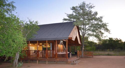 a small cabin with a black roof at Pezulu Tree House Lodge in Hoedspruit