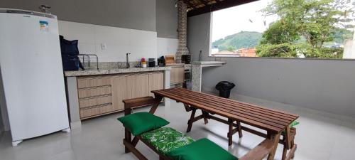 cocina con mesa de madera y 2 sillas en Casa do Sérgio, Lindo loft-02 moderno e confortável., en Paraty