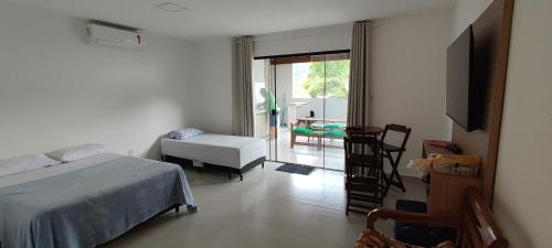 a bedroom with a bed and a table and a chair at Casa do Sérgio, Lindo loft-02 moderno e confortável. in Paraty