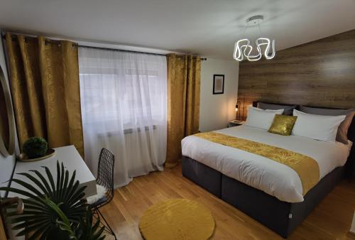 ein Schlafzimmer mit einem großen Bett und einem Kronleuchter in der Unterkunft Sun Deluxe Apartment in Banja Luka