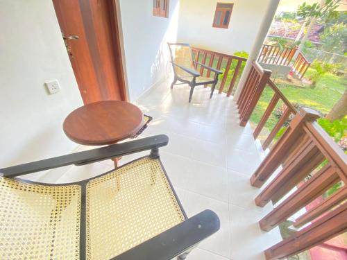 a room with a table and chairs on a balcony at Sanderling Silent Beach Cabanas in Tangalle