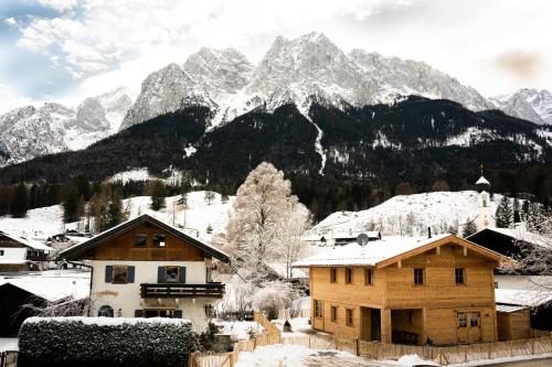 格賴瑙的住宿－Stefan Glowacz CHALET mit traumhaftem Bergblick，一片雪覆盖的山脉,前方有一座房子