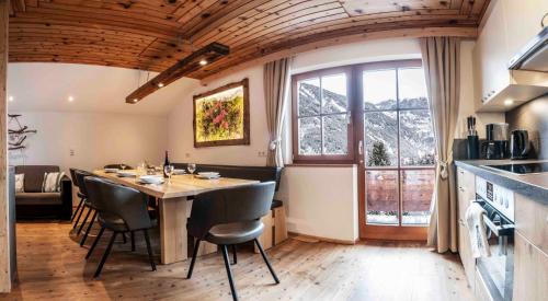 a kitchen with a table and chairs in a room at Wiesenhof in Kaunerberg