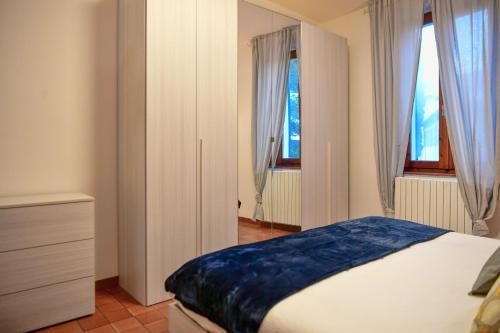 ein Schlafzimmer mit einem Bett und zwei Fenstern in der Unterkunft Quadrifoglio Apartment by Wonderful Italy in Bellagio