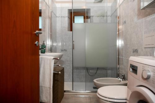 ein Bad mit einer Dusche, einem WC und einem Waschbecken in der Unterkunft Quadrifoglio Apartment by Wonderful Italy in Bellagio