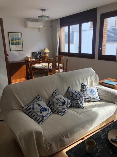 a living room with a couch with pillows on it at Joli appartement centre avec terrasse vue mer in Tossa de Mar