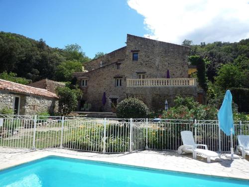 une villa avec une piscine en face d'une maison dans l'établissement La Petite Grange, à Reynès