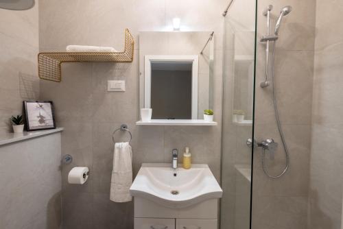 a bathroom with a white sink and a shower at Apartment Bili-sea view apartment in the center in Makarska