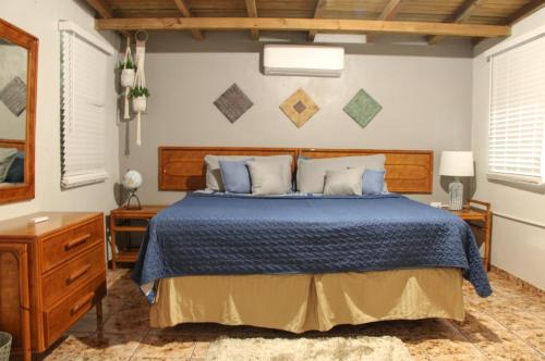 a bedroom with a bed with a blue comforter at Casa Isabel in Rincon