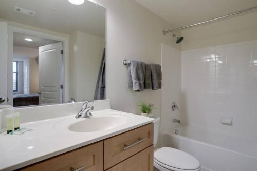 uma casa de banho com um lavatório, um WC e um chuveiro em Stunning Apt with Gym at Pentagon City em Arlington
