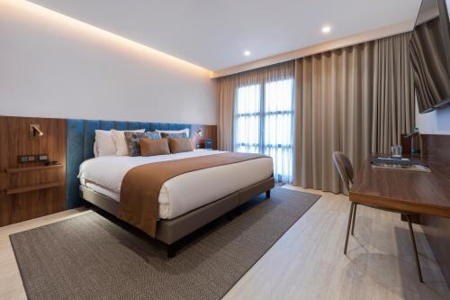 a bedroom with a bed and a desk and a television at The Duke Boutique Hotel in Victoria