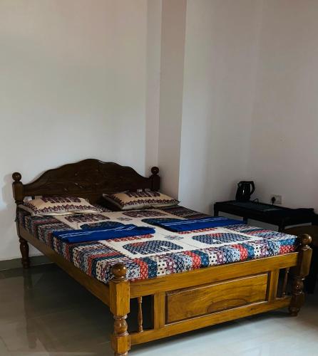 a bed with a quilt on it in a room at St francis xavier spacious rooms in Old Goa