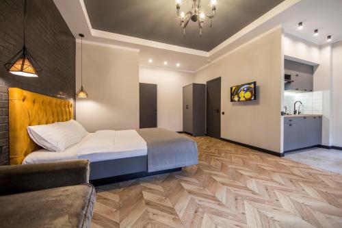 a bedroom with a bed and a couch and a kitchen at DayFlat Apartments Maidan Area in Kyiv