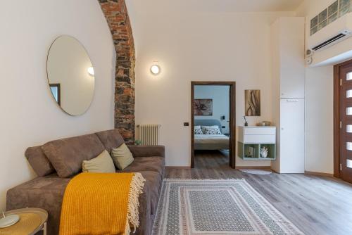 a living room with a couch and a mirror at Cernobbio Charming APT! in Cernobbio