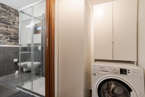 uma máquina de lavar roupa na casa de banho com WC em Cernobbio Charming APT! em Cernobbio