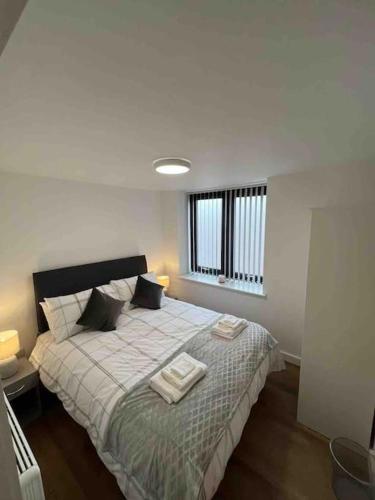 a bedroom with a bed with two towels on it at Newly built 2 bed flat in the heart of Leek in Leek
