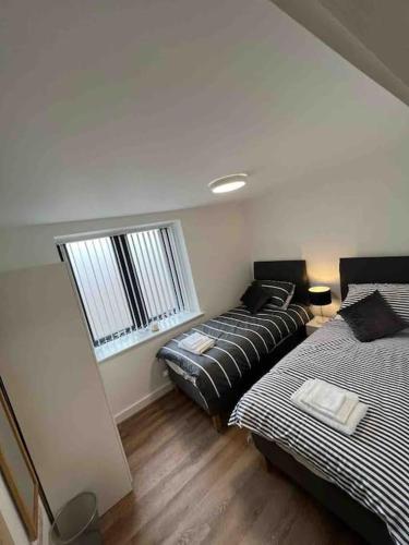 Habitación con 2 camas y sofá. en Newly built 2 bed flat in the heart of Leek, en Leek