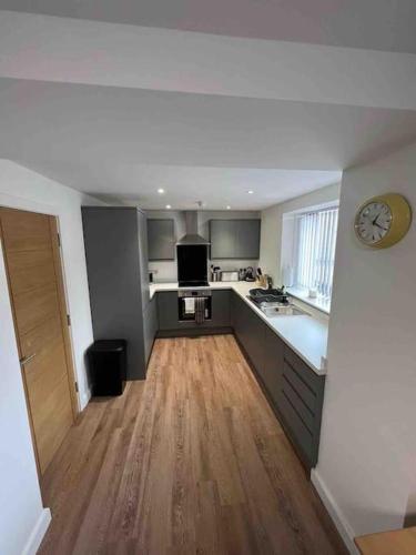 a large kitchen with a clock on the wall at Newly built 2 bed flat in the heart of Leek in Leek