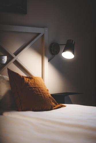 a bedroom with a bed with a pillow and a lamp at Åtellet Hotell in Norrtälje