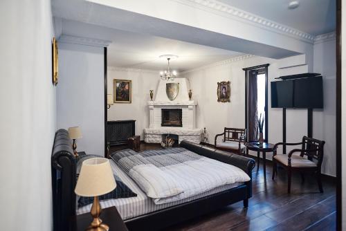 a bedroom with a bed and a fireplace at La Conac Resort in Hulubeşti