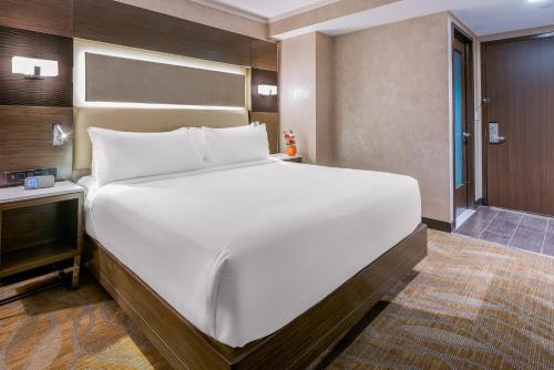 a bedroom with a large white bed and a table at Holiday Inn Brooklyn Downtown by IHG in Brooklyn