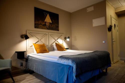 a bedroom with a large bed with yellow pillows at Åtellet Hotell in Norrtälje